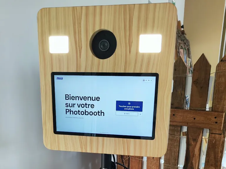 Borne photobooth devant une barrière en bois de décoration champêtre