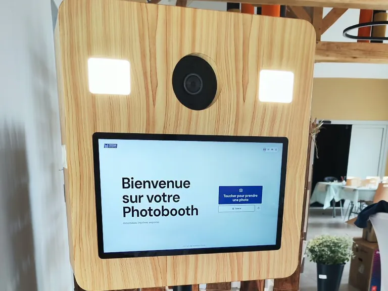 Borne photobooth en bois dans une salle de réception aux poutres apparentes