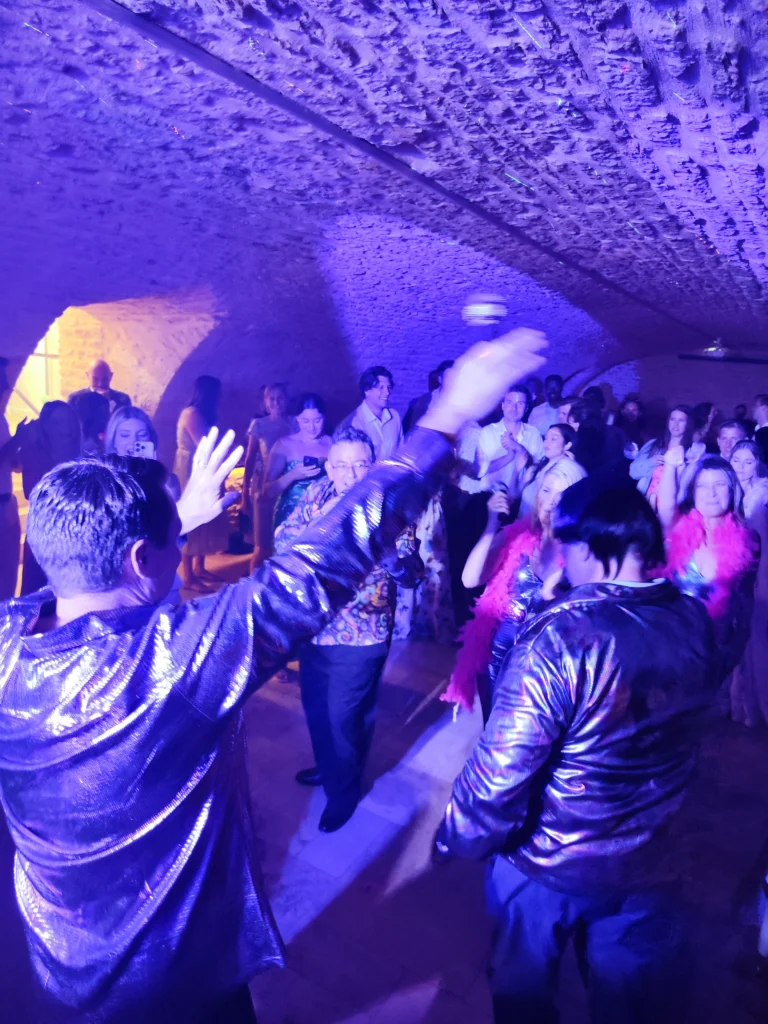 Invités dansant dans une cave voûtée en pierre éclairée en violet, avec boule à facettes, lors d'une soirée DJ Médian Events près de Chalon-sur-Saône